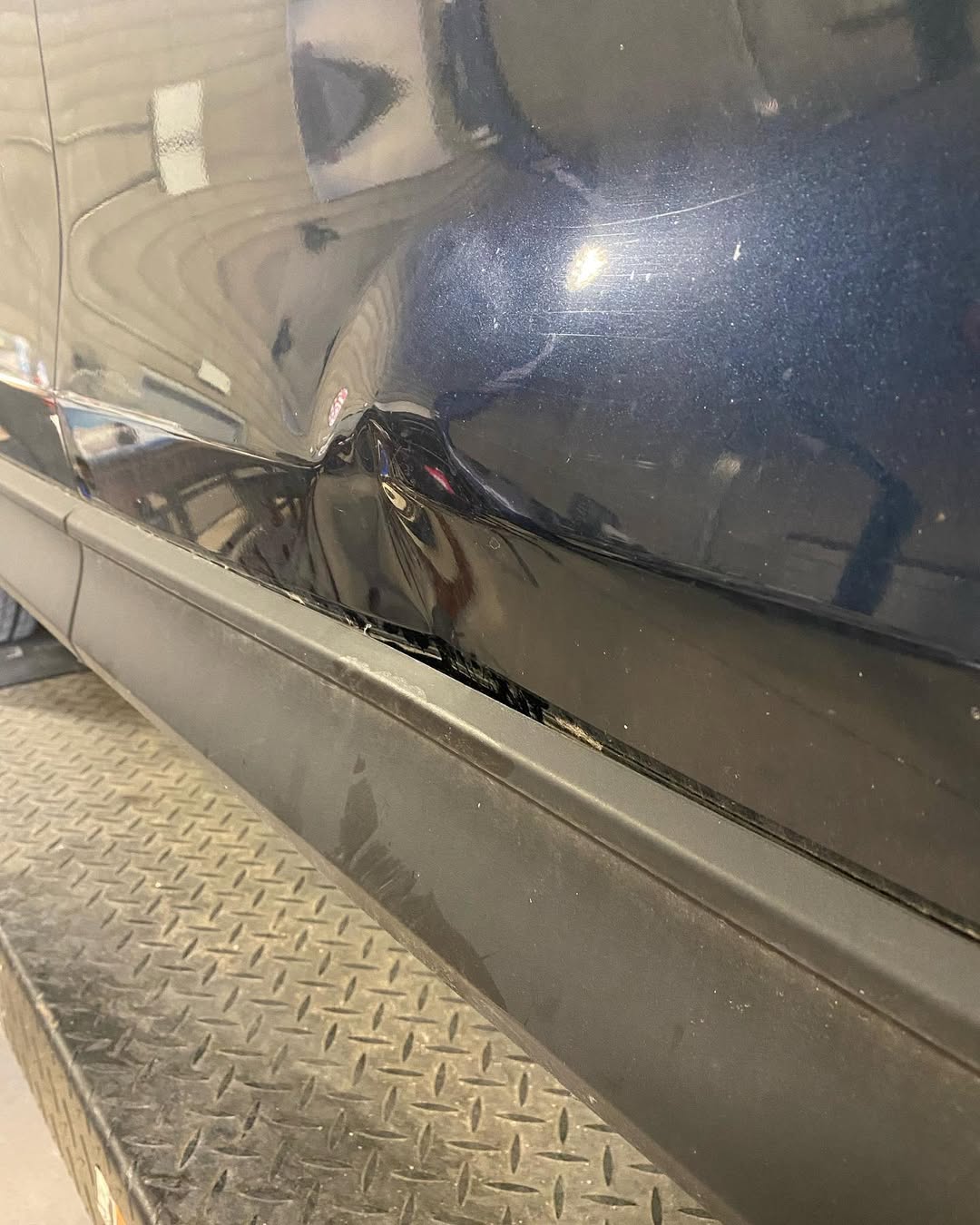 Black car panel with scratches and swirl marks